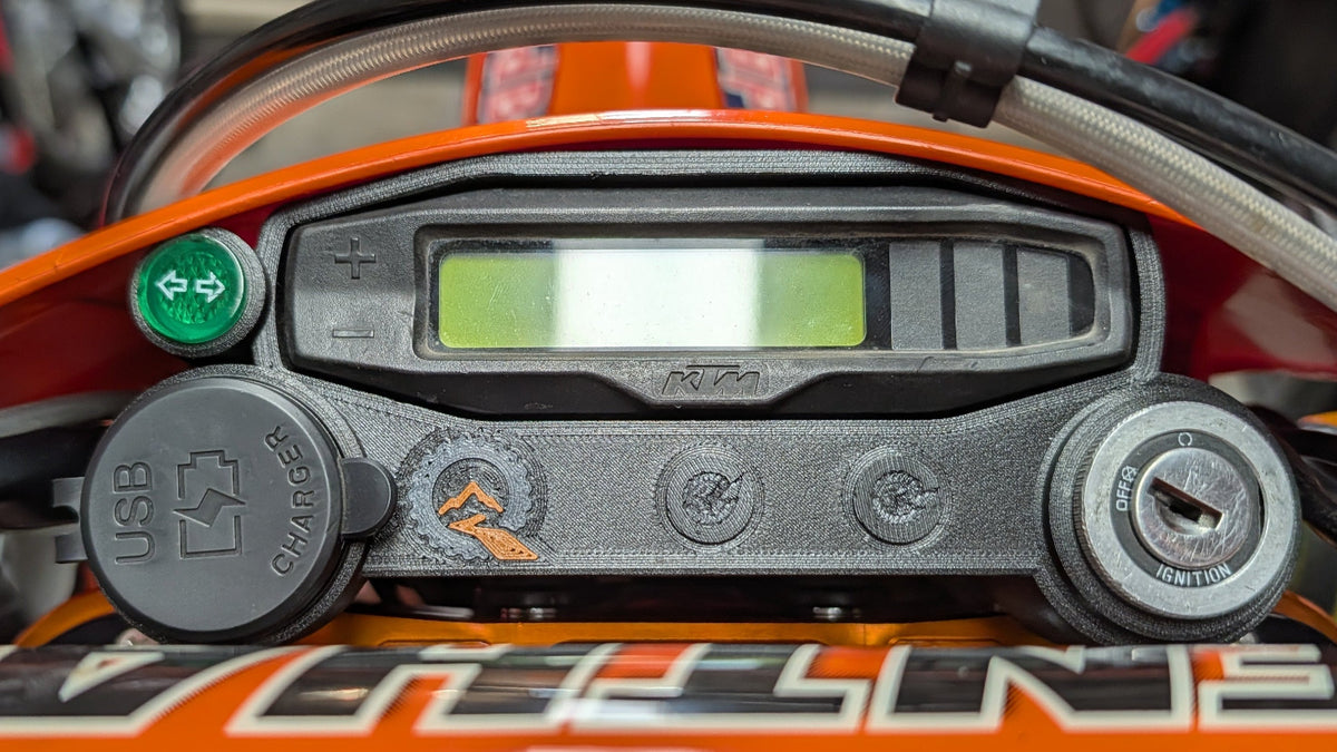 Quinnware dashboard installed on a KTM EXC-F with speedometer, USB outlet, indicator light, and ignition switch